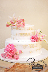Two tier semi- naked cake has a pearl border and fresh flower accent.