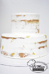 Two tier semi naked cake with adorned with gold flakes.