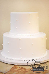 Two tier smooth cream frosting with swiss dots and pearl border.