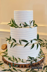 This three tier cream spoon effect cake is garnished with beautiful branches that finish the design of the cake.