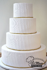 This four tier combed cream cake with gold ribbon is a simple statement piece that will impress your guests.