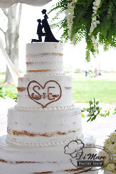 Four tier semi naked cream cake with initials engraved in second tier.