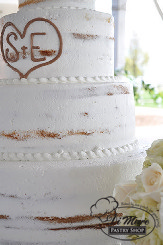Four tier semi naked cream cake with initials engraved in second tier.