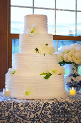 Four tier spoon effect cake accented with beautiful silk flowers.