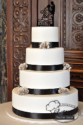 This four tier cake is wrapped with black ribbon and garnished and topped with unique paper flowers to wow you guests!