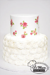 This two tier cake has a white rosette bottom with a smooth top tier with images of roses accenting the top tier.