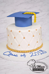 Blue and gold fondant pin cushion cake finished off with a graduation cap.