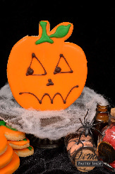 A butter iced cookie with threatening Jack-O-Lantern face.