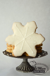 Delicate snowflake shaped cookies, covered in icing and sprinkled with edible glitter.