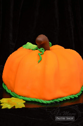 A delicious pumpkin shaped cake with beautiful colors.