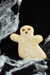 A large butter cookie in the shape of a ghost topped with sanding sugar and garnished with chocolate chips.
