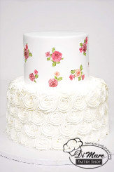 This two tier cake has a white rosette bottom with a smooth top tier with images of roses accenting the top tier.