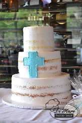 Semi- naked three tier Christening cake accented with a blue cross.