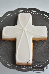An iced cookie in the shape of a cross, can be customized.