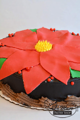 A beautiful poinsettia crafted from fondant on top of one of our classic chocolate cakes with chocolate buttercream.