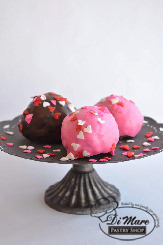 Regular and chocolate cheesecakes shaped into cakeballs topped with ganache and sprinkled with Valentine's Day sprinkles!