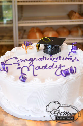 Topped with curling ribbon and a graduation cap, this whipped cream cake is a nice way to celebrate you Graduate.